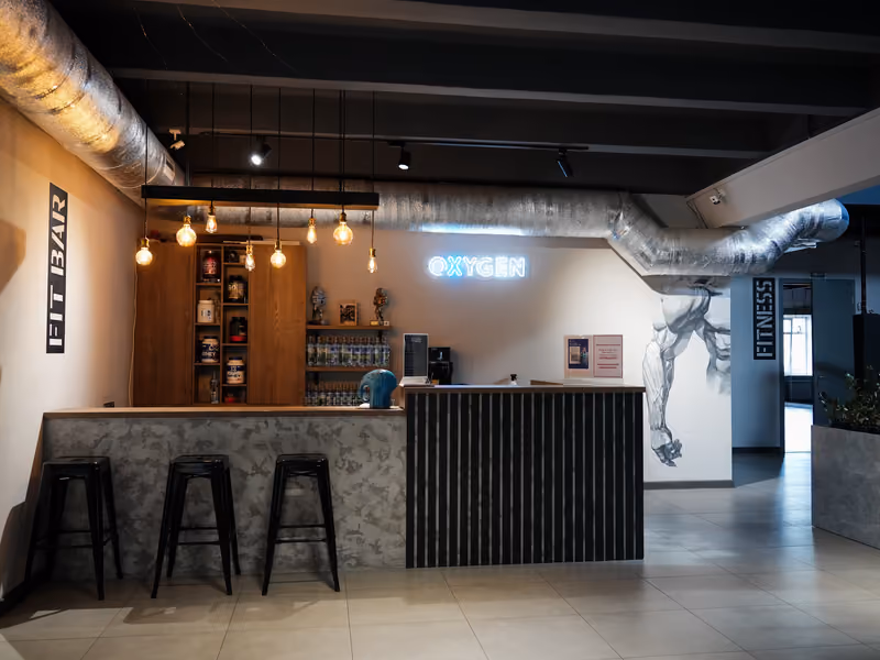 Fit bar клуба с неоновой вывеской OXYGEN и барными стульями.